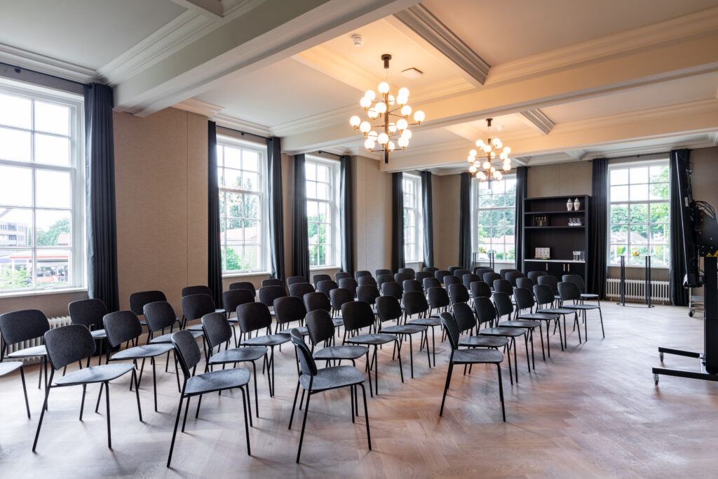 De stijlvolle zaal van de Mauritskazerne in Ede met klassieke kroonluchters en hoge ramen, klaar voor de Strategische Meta Ads Meeting