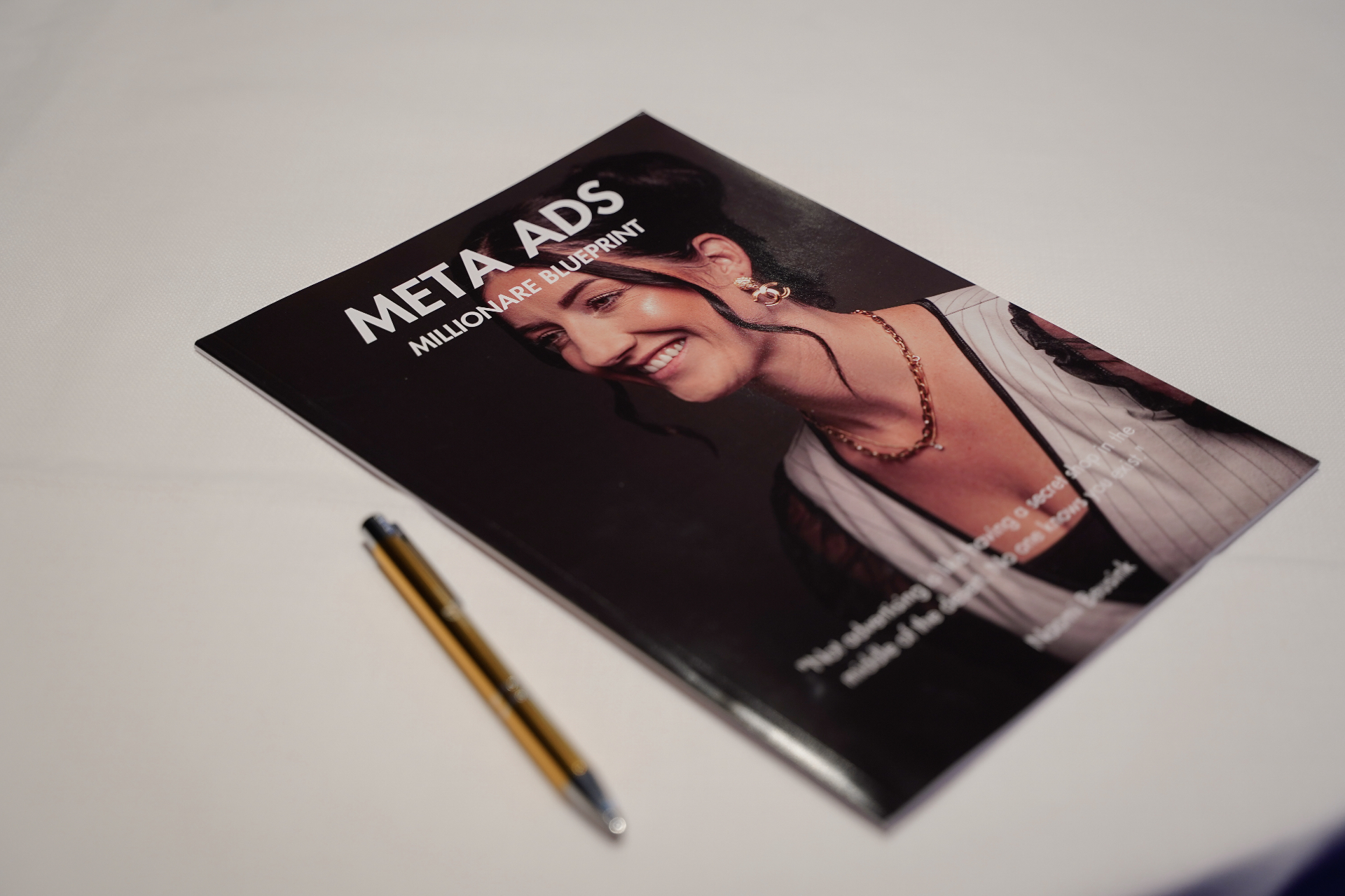 Het Meta Ads Millionaire Blueprint magazine van Naomi Beusink op tafel met een pen ernaast